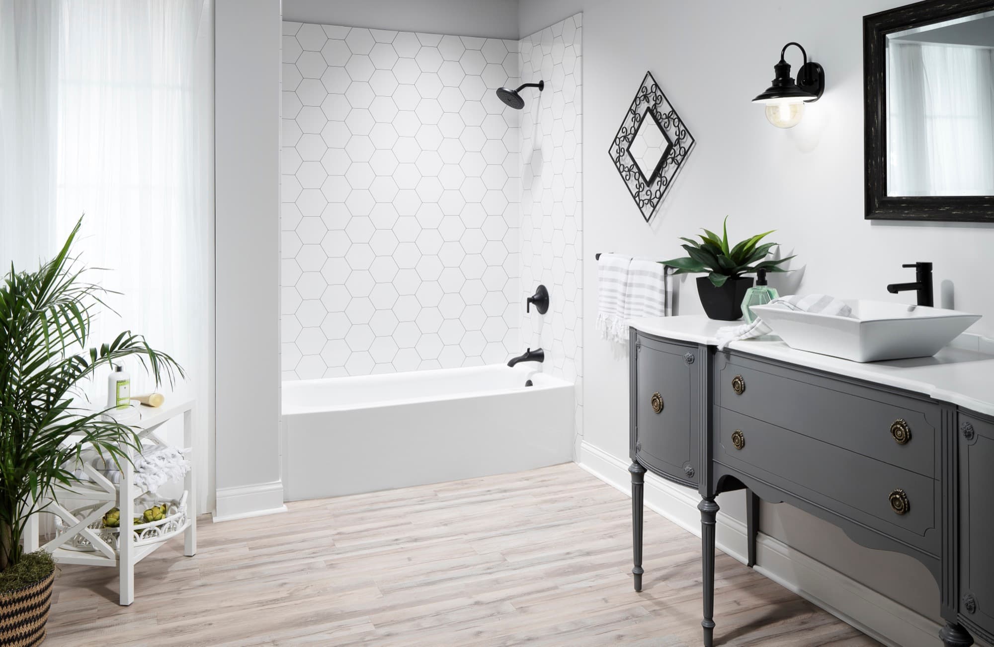 White tub surround with geometric wall panels and matte black fixtures