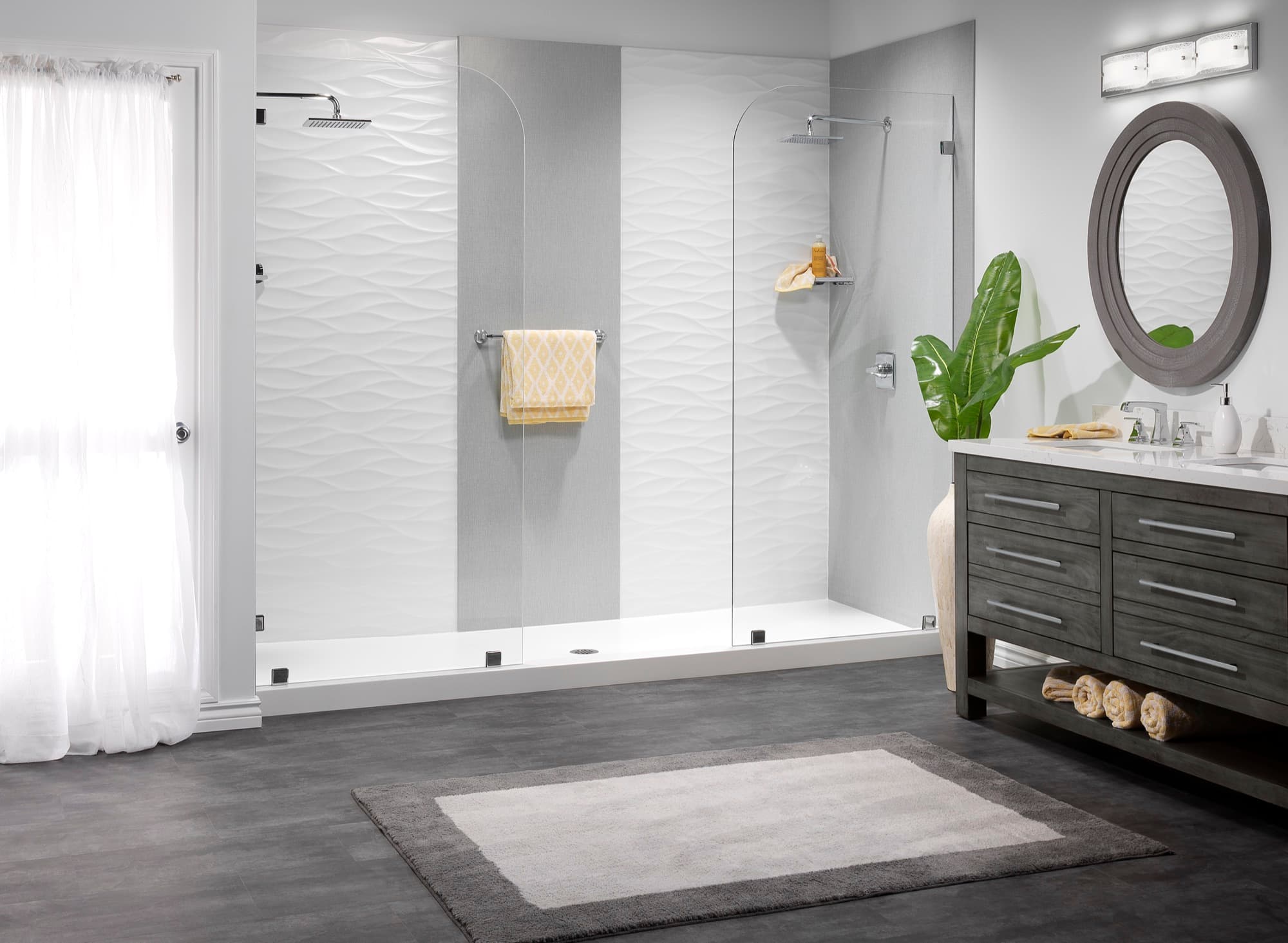 Dimensional wave-textured shower panels beside a dark vanity and round mirror